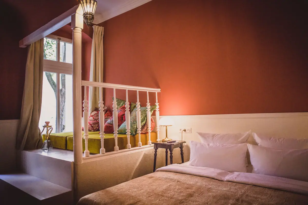 HENRI Berlin Orient Room A bed with pillows and a lamp in a room.