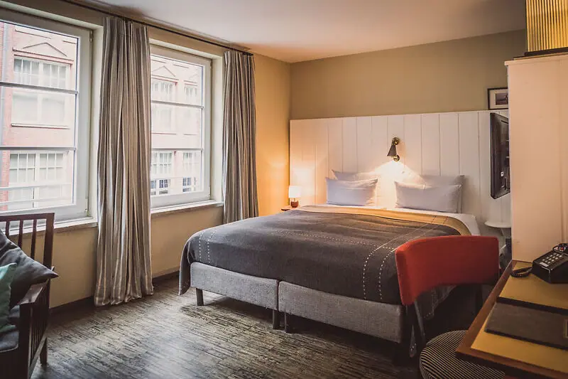 Rooms at the HENRI A bedroom with a bed and a desk.