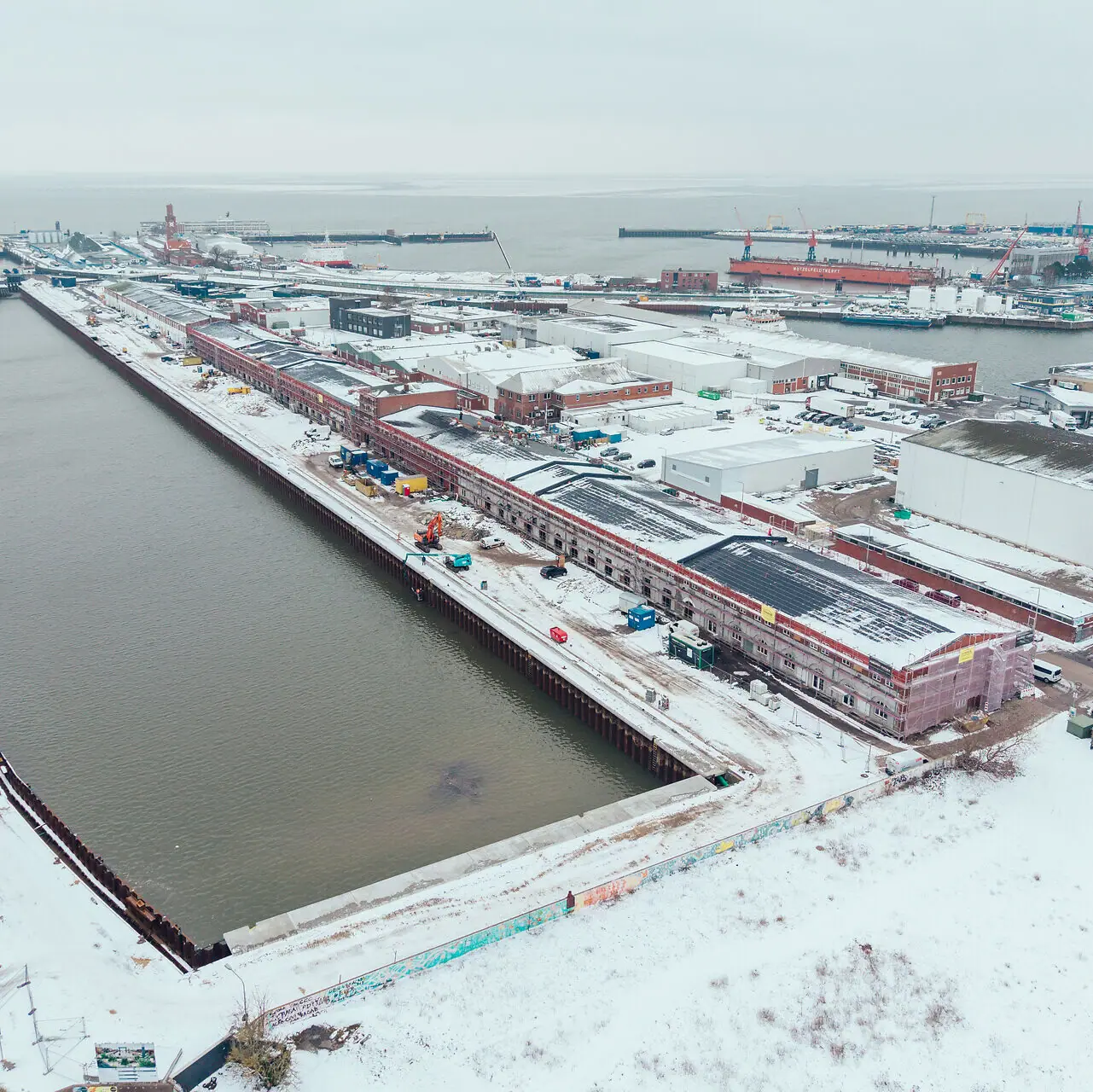 HENRI Hotel Cuxhaven A bird's eye view of a snow-covered town next to a body of water in winter.