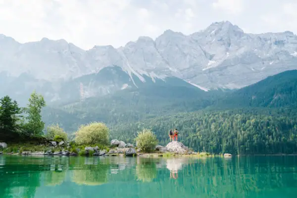 Lake near Garmisch-Partenkirchen People standing on a rock in front of a lake.