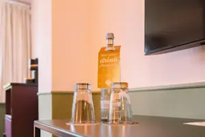 Hotel room Chambre at the HENRI Hotel Garmisch-Partenkirchen A bottle and glasses on a table.