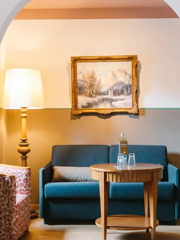 Hotel room living area A room with a sofa and a coffee table.