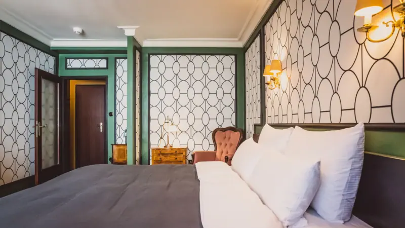 Room view A bed with pillows and a chair in a room.