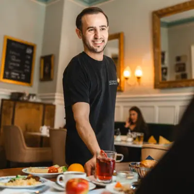 HENRI employee Man A man smiles at a table with food.