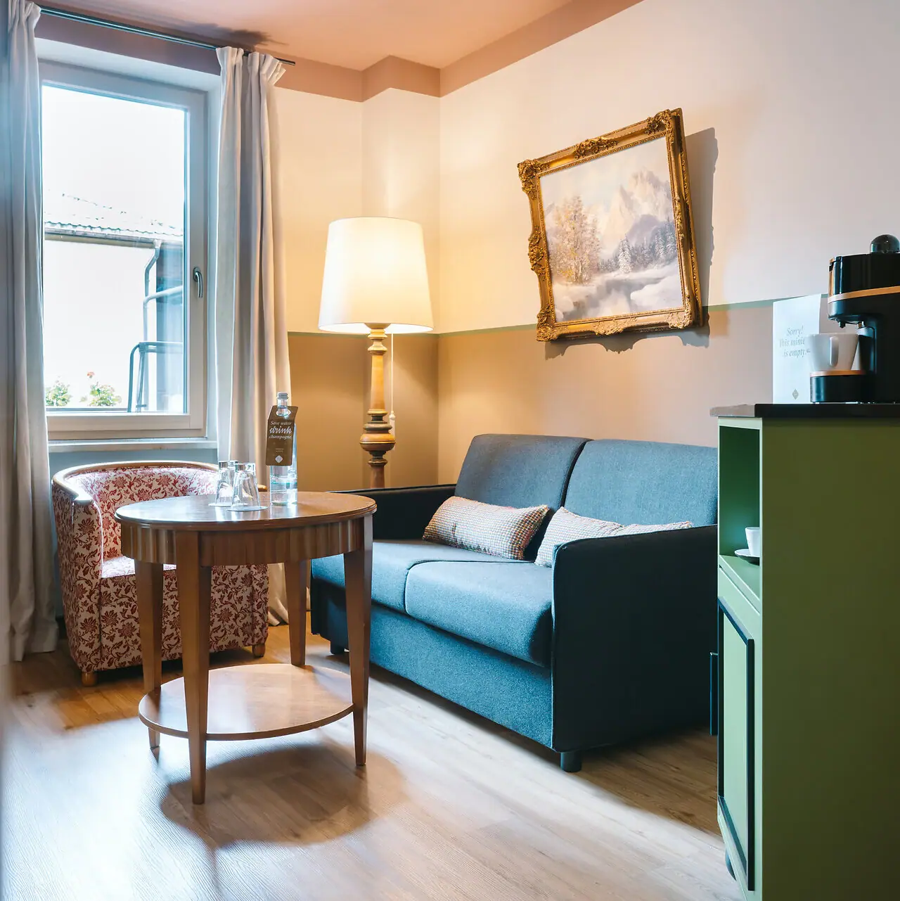 Hotel rooms at the HENRI Garmisch-Partenkirchen Living area in a hotel room at the HENRI Garmisch-Partenkirchen with a sofa and a table.