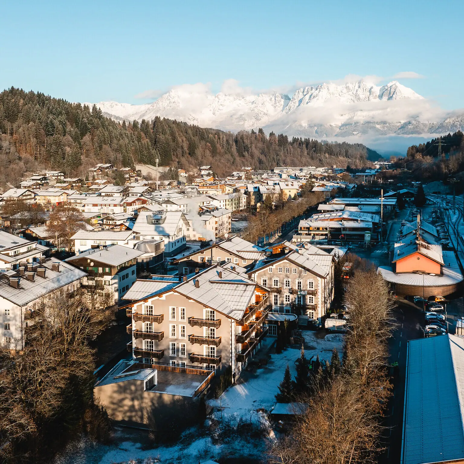 HENRI Hotel Kitzbühel Snow-covered town in winter with houses in the background.