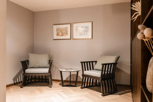 Sitting area in the wellness area A room with chairs and a table, furnished with a sofa, wooden floor and a coffee table.