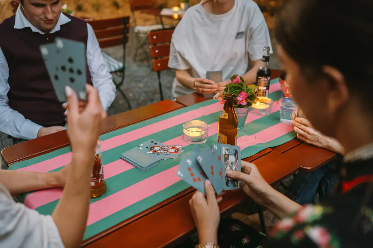 Card game A group of people are sitting at a table playing cards.