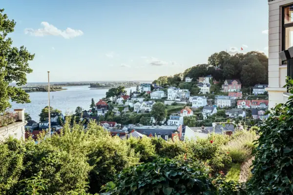 Staircase district City view with water in the foreground, surrounded by buildings and trees under a cloudy sky.