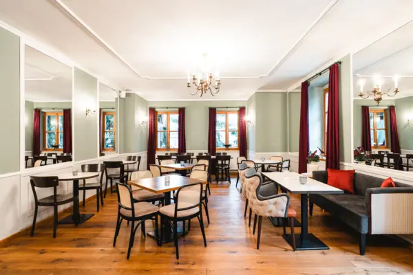 Hall of Mirrors at the HENRI Hotel Kitzbühel A room with tables and chairs.