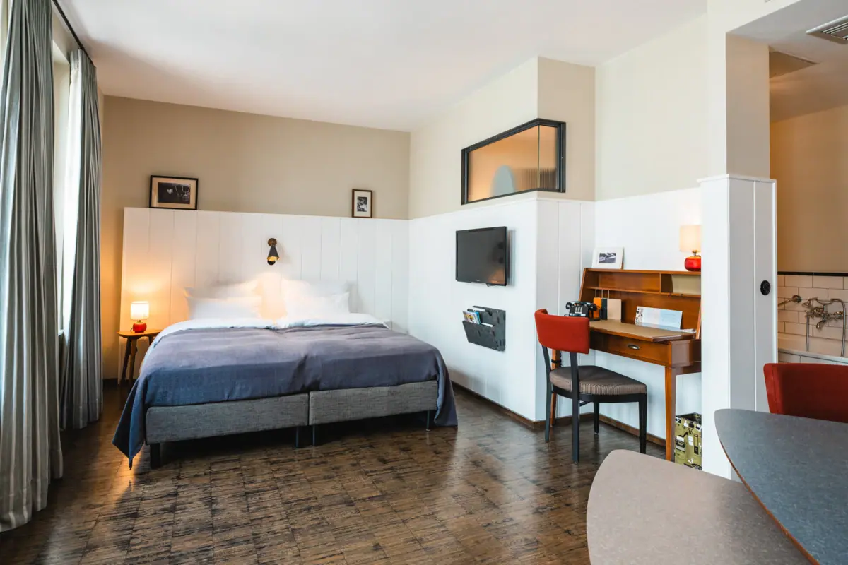 Rooms at the HENRI Hotel Hamburg A room with a bed and a desk.
