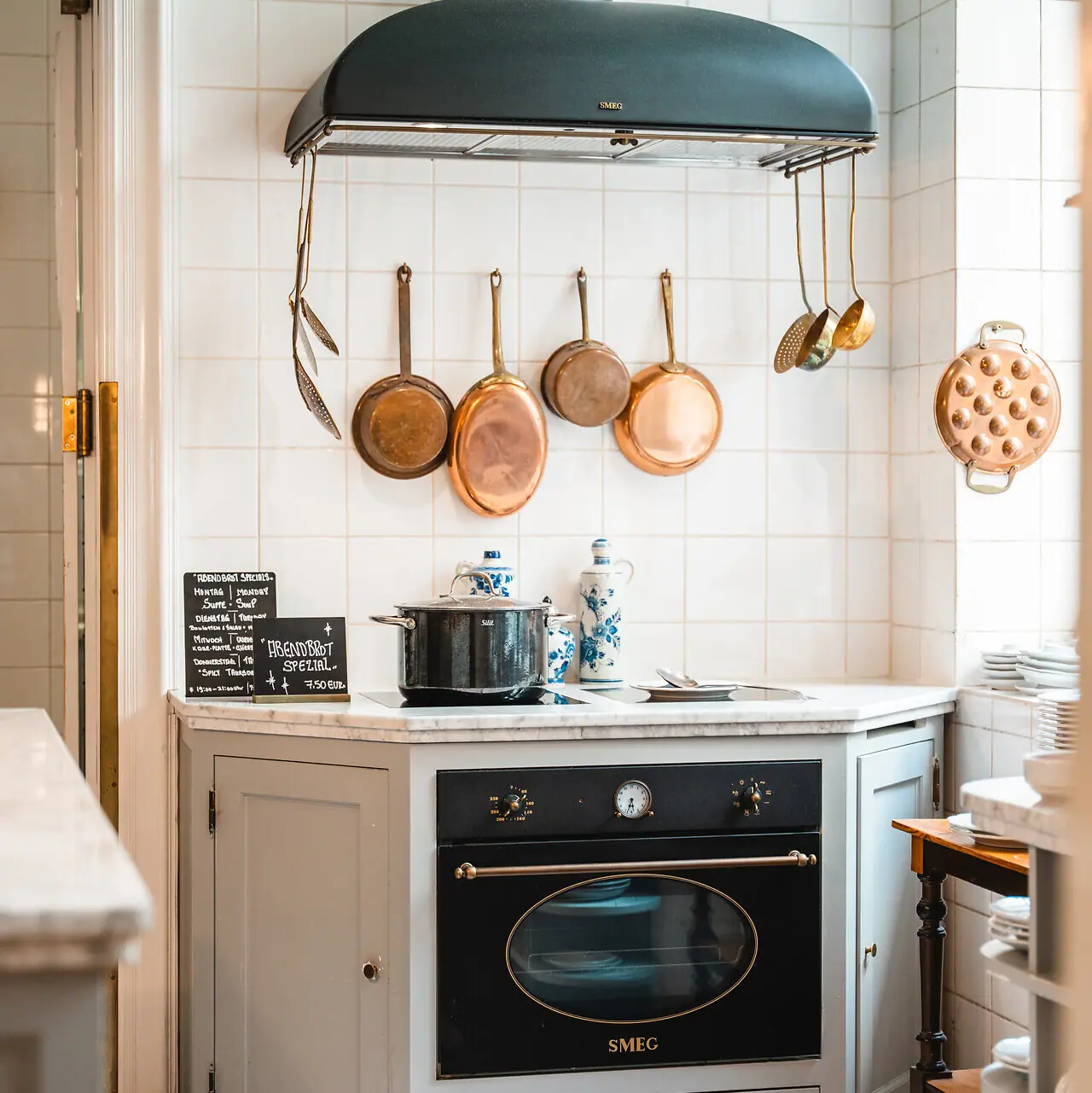 Kitchen at HENRI Berlin A kitchen with a cooker and pots on the wall.