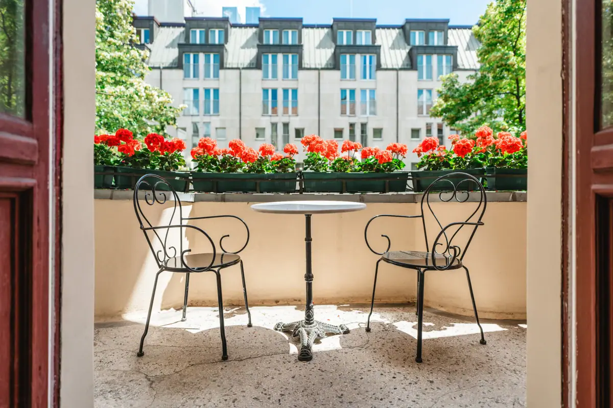 HENRI Berlin Room Ballcon A table and chairs on a terrace.