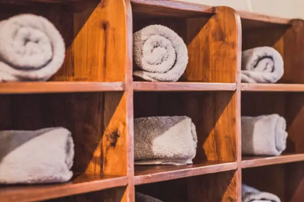 Wooden shelf with rolled white towels Wooden shelf with rolled white towels