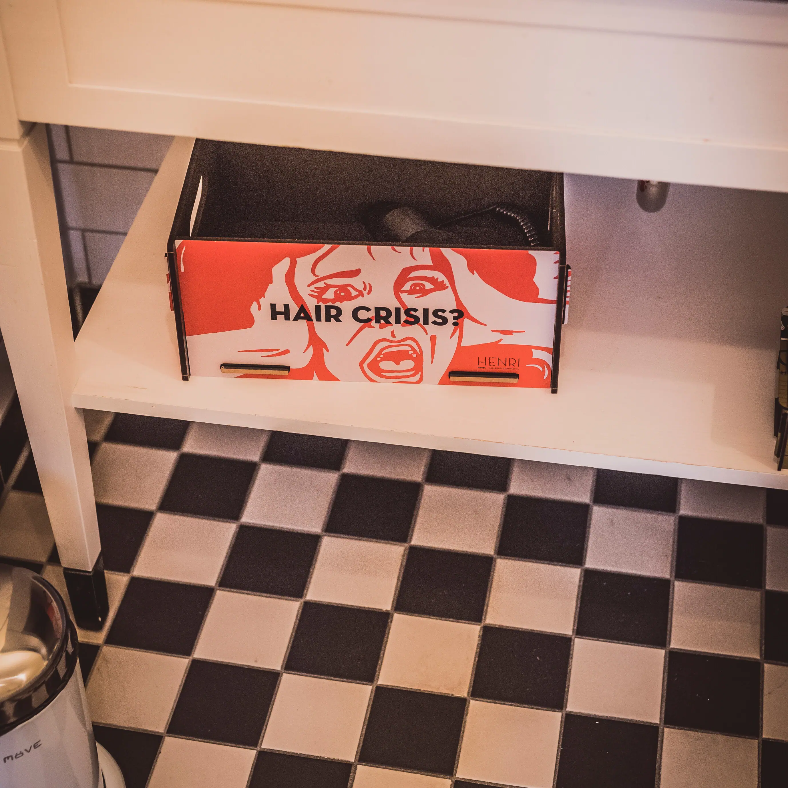 Detail picture from the bathroom Colourful box with hairdryer on a bathroom shelf
