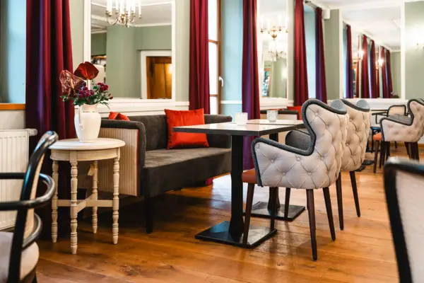Hall of Mirrors at the HENRI Hotel Kitzbühel A room with a sofa, tables and chairs.