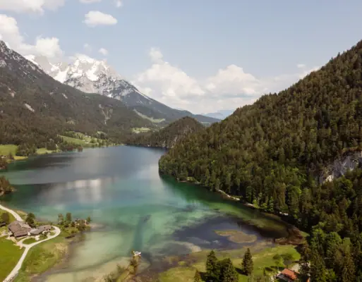 lake near Kitzbühel A lake surrounded by trees and mountains.