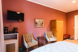 Room view A room with a bed, two chairs and stylish interior design.