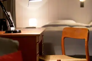 Desk A desk with a lamp and a chair.