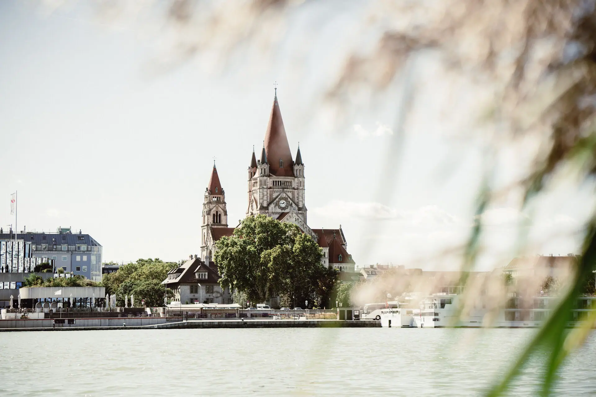 Church A building with a clock tower and trees by a lake.