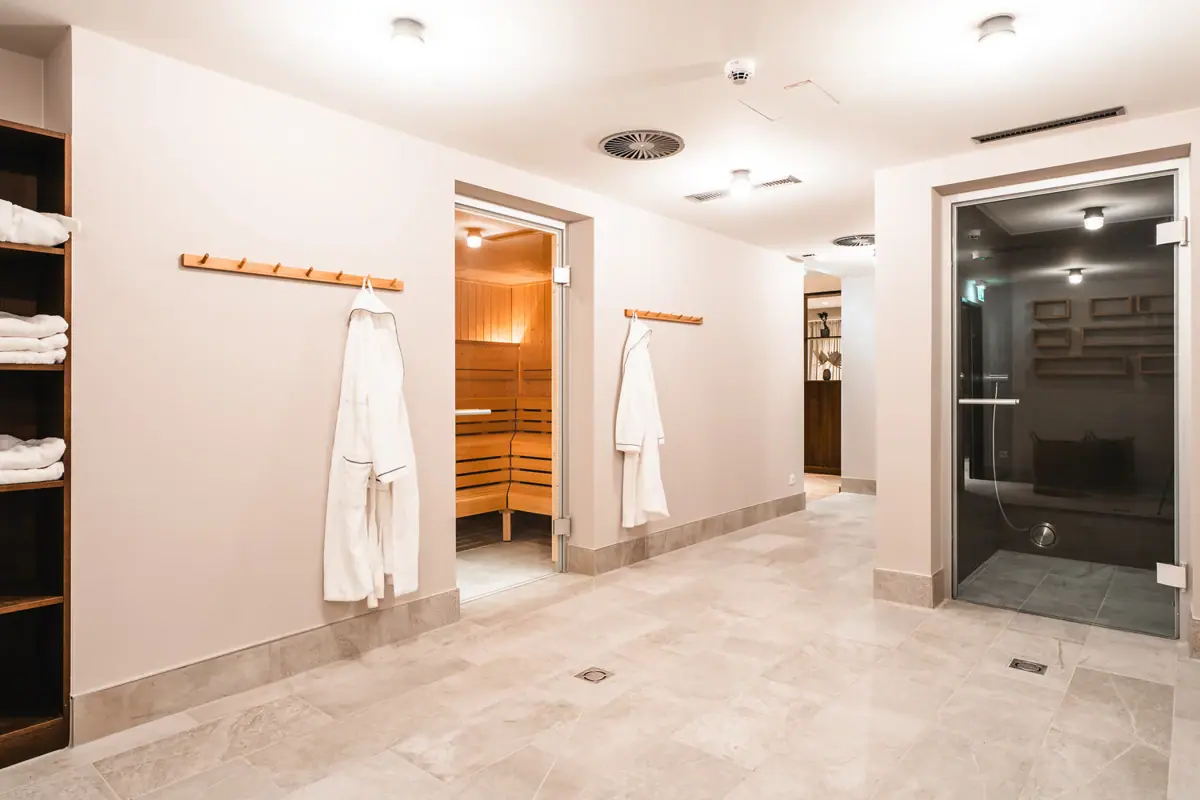 Sauna area HENRI Kitzbühel A room with white bathrobes and a sauna.