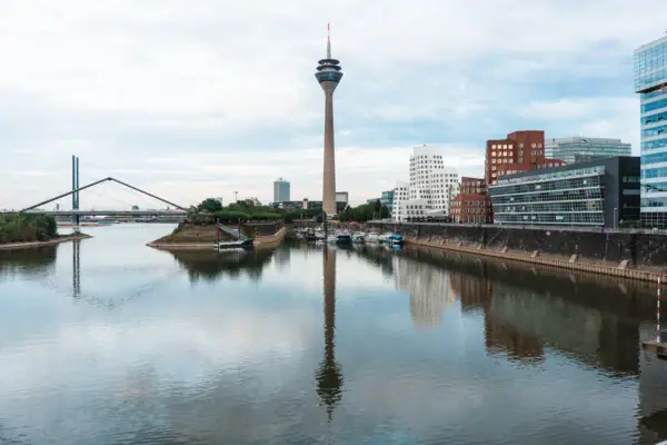 Skyline Düsseldorf The skyline of Düsseldorf with a river in the foreground and a tower in the background.
