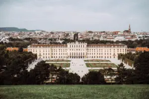 Castle Large building with a courtyard and garden, surrounded by trees and grass under a partly cloudy sky.