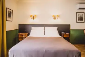 Vienna Hotel Room A bed with two wall-mounted lamps in a hotel room.