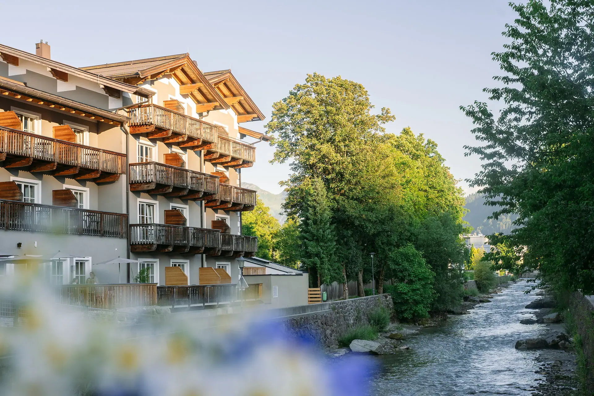 HENRI Kitzbühel A building next to a river.
