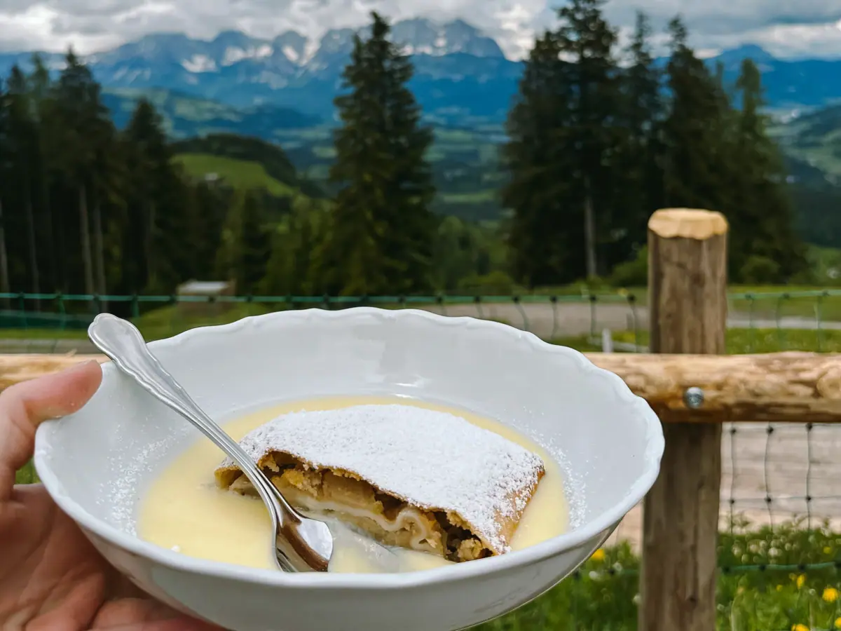 One hand holds a bowl of food and a spoon.
