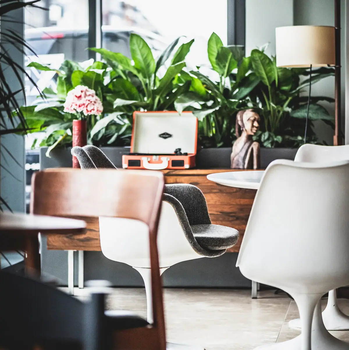Lounge A room with chairs, a table and a plant.