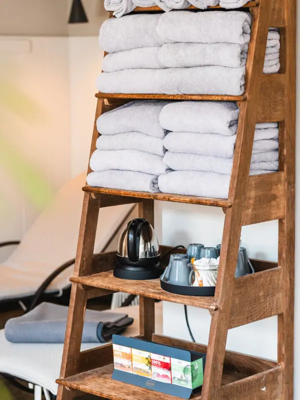 Shelf with towels A pile of towels on a wooden shelf.
