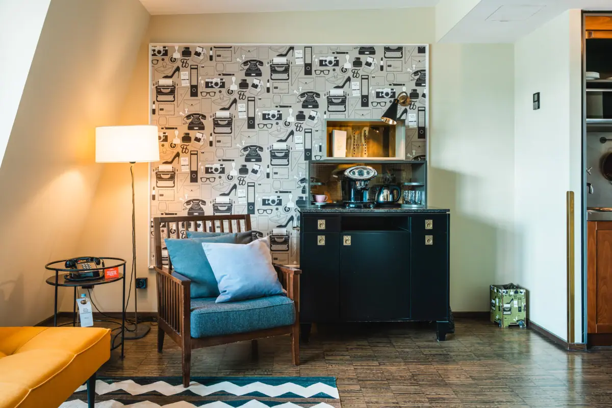 Living room furnishings in a HENRI Suite Armchair and cupboard with coffee and tea station
