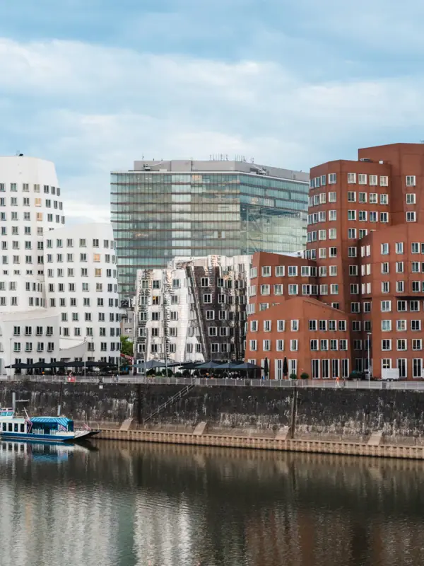 Düsseldorf A river with boats and buildings in the background.