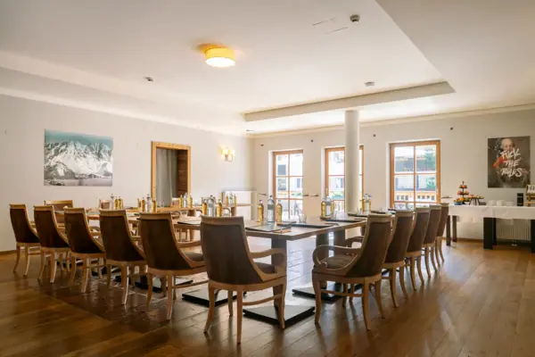 Room Ache Gallery 1 in the HENRI Hotel Kitzbühel A room with a table and chairs.