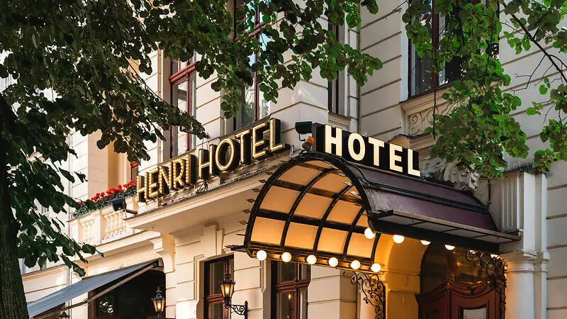 HENRI Hotels Hotel building with illuminated façade and windows.