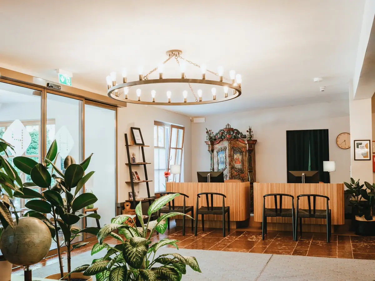Reception at the HENRI Hotel Kitzbühel A room with a chandelier and chairs.