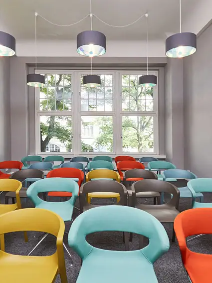 Coworking space in Hamburg A room with lots of colourful chairs.