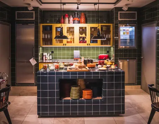 HENRI Evening meal A kitchen with counter and chairs.