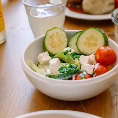 A bowl of mixed salad A bowl of salad with cucumber and tomatoes.