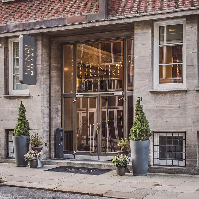 Entrance HENRI Hotel Hamburg A building with glass doors and a sign.