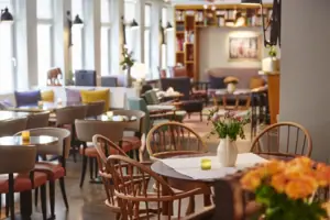 Open-plan lounge at the HENRI Hotel Hamburg Tables and chairs in the lounge area