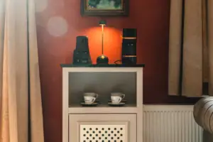 Salon Haus Kaiser HENRI Kitzbühel A room bar at the HENRI Kitzbühel with cups and a lamp on top.