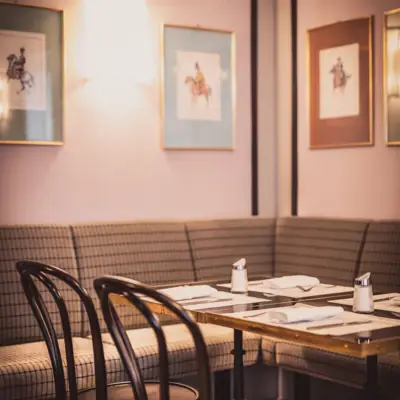 Reiterstüberl in the HENRI Vienna A table with a set of napkins and chairs in a restaurant.