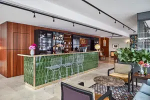 HENRI Düsseldorf A bar with green tiles and chairs.