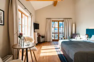 Bedroom Spacious room with table and double bed, flooded with light from the many windows.