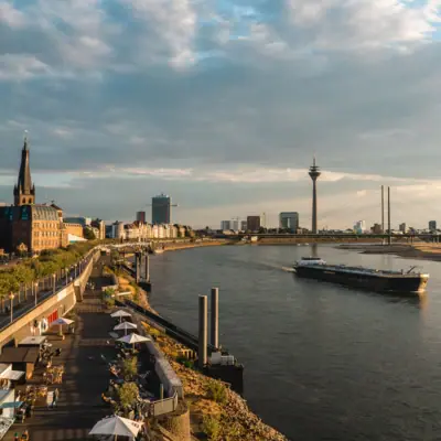 Düsseldorf Rhine bank A river with a boat on it.