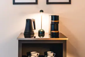 Coffee and tea station Kettle, coffee machine and cups on a shelf