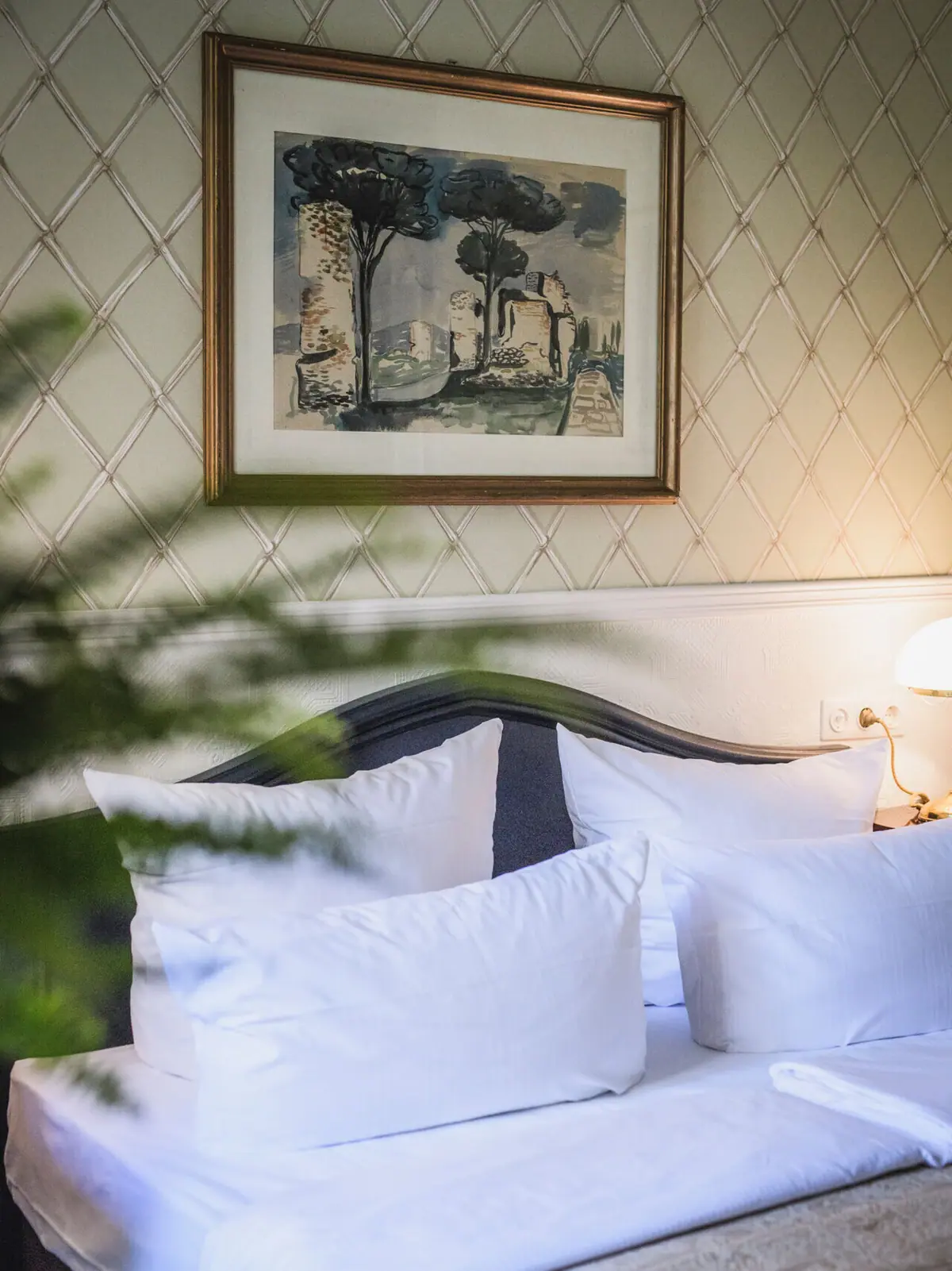 HENRI Berlin Anthroposophists' Room Bed with 2 pillows in front of an antique wallpaper