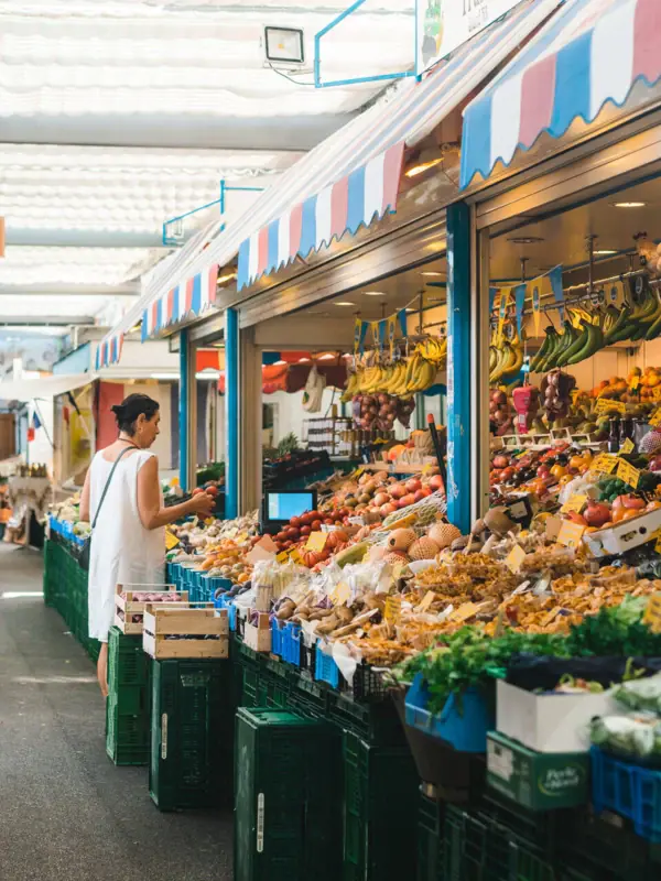 Düsseldorf Woman standing in front of a fruit stall at a market.